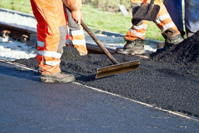 Worker flattening asphalt